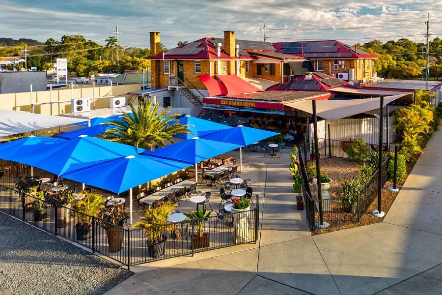 Aerial view of the Esk Grand Hotel including the blue umbrellas over the back outdoor dining area and building.
